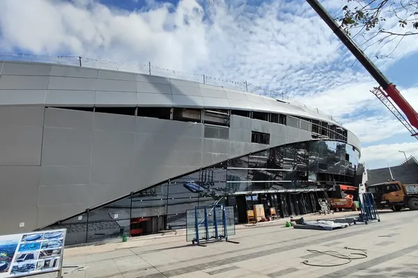 Botswana sports arena facade under construction with glass and aluminium panels visible