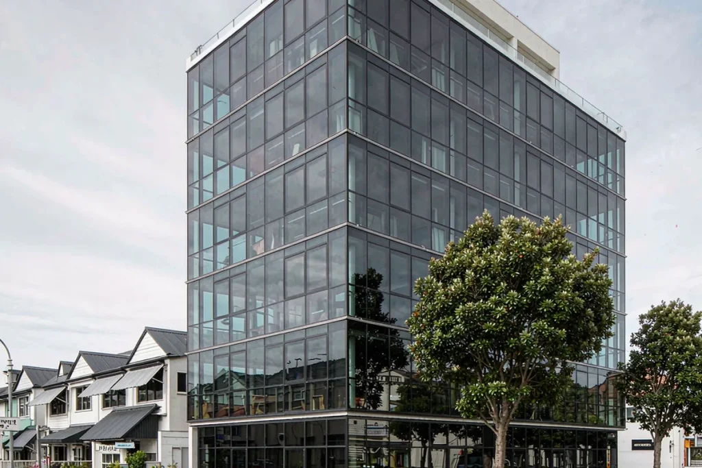 Six-storey corner apartment building with a stick curtain wall facade and ground-floor retail glazing