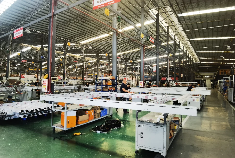 Organised curtain-wall assembly hall with long aluminium frame workstations