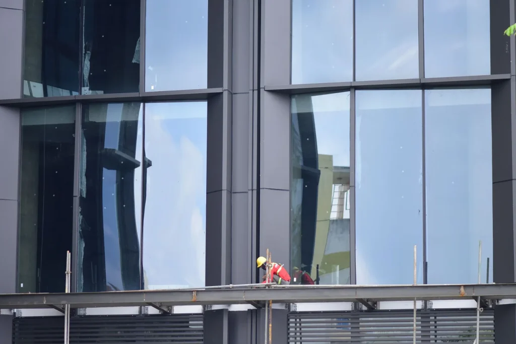 Facade installer working on a glazed elevation from scaffolding