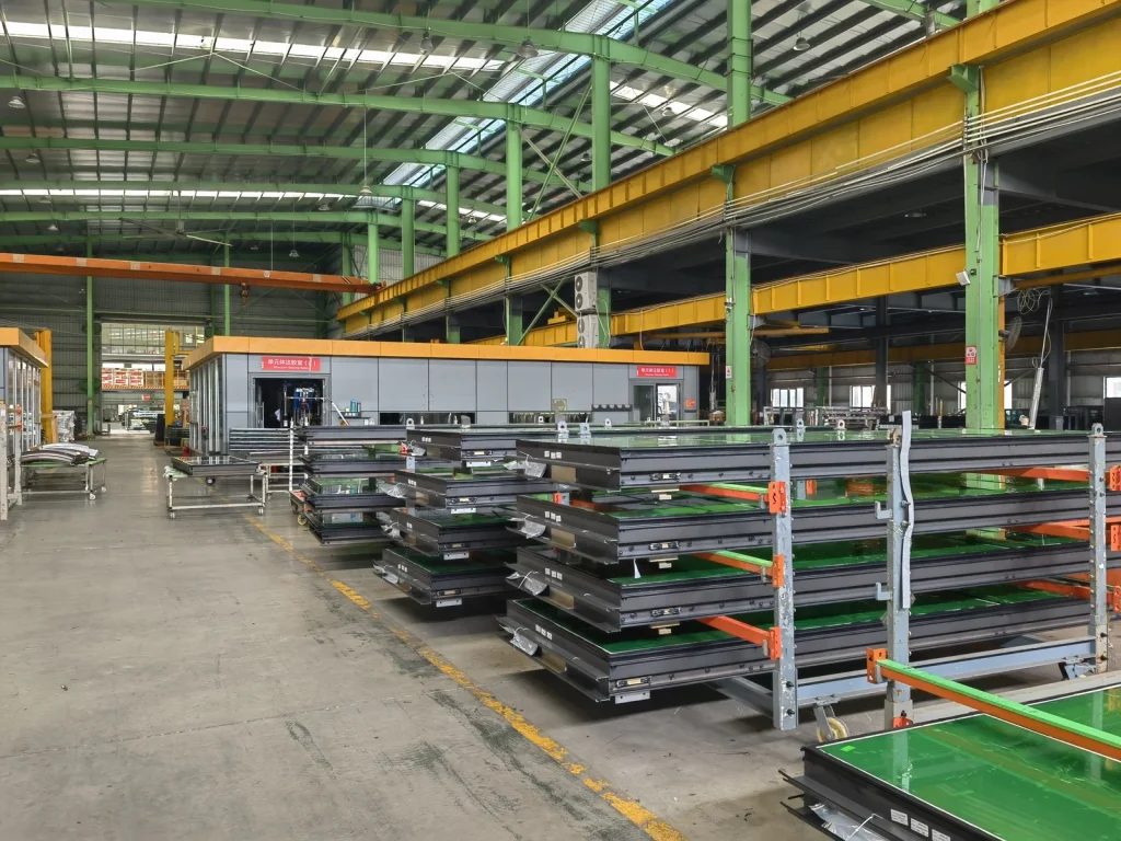 Unitised curtain wall panels stacked on curing racks after glazing